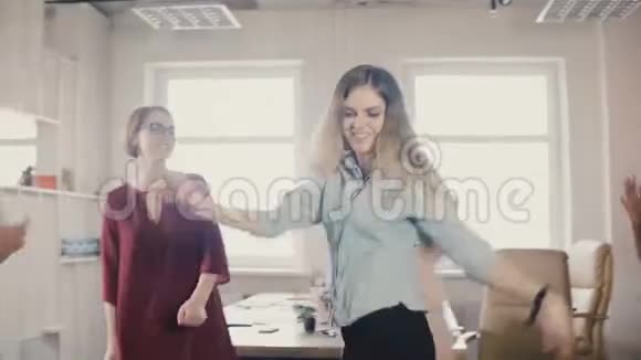 快乐的女孩在办公室聚会上跳月游舞各族员工共舞庆祝商业成功视频的预览图