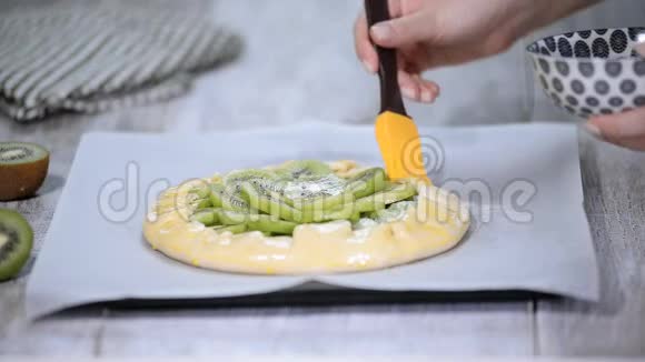 用新鲜的猕猴桃做一个厨房的过程女厨师用鸡蛋润滑面包店的产品视频的预览图