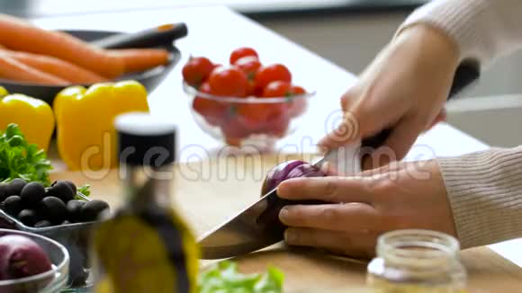 年轻女子在家里切红洋葱视频的预览图