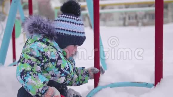一个小孩在冬天的公园里玩雪阳光明媚的冬天白天新鲜空气中的乐趣和游戏视频的预览图