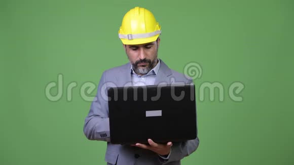 一个英俊的波斯胡子商人在使用笔记本电脑时思考问题视频的预览图