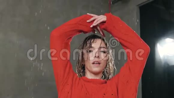 一个女孩看着摄像机她的头发被雨水淋湿了湿漉漉的女孩跳现代舞视频的预览图