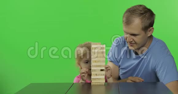 父亲和女儿扮演简加小孩子从塔上拿出木块视频的预览图