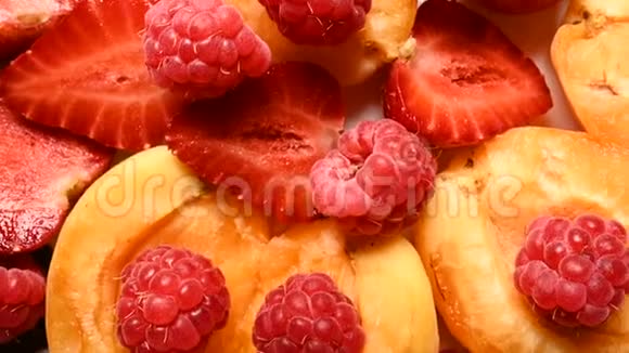 在盘子里的杏子旁边放上红色草莓和覆盆子现场摄像机美味的概念视频的预览图
