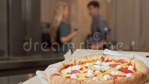 桌上有美味的披萨背景上有两个人一起喝酒视频的预览图