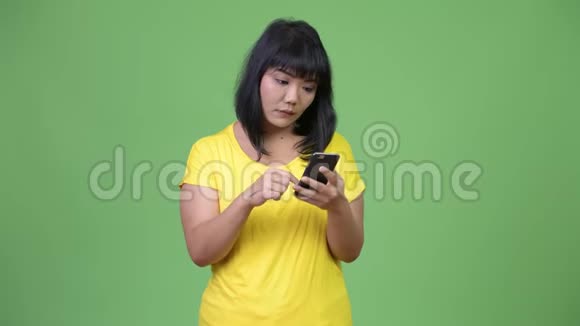 美丽的亚洲女人用手机看起来很震惊视频的预览图