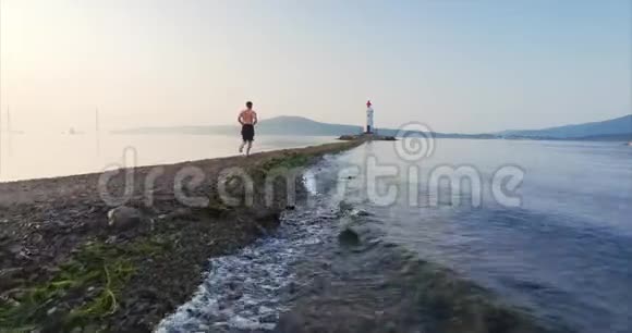 低飞在海波之上运动员沿着唾沫奔跑的鸟瞰图视频的预览图