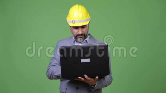 一个英俊的波斯胡子商人在使用笔记本电脑时思考问题视频的预览图