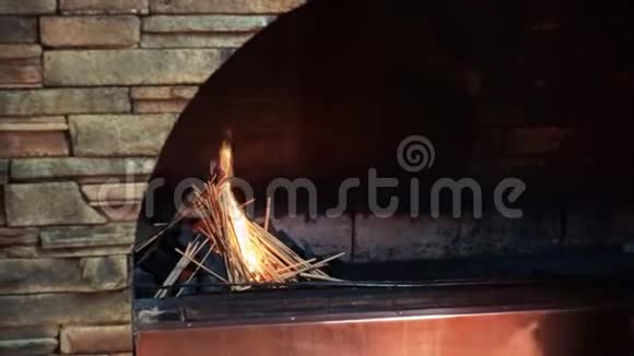 人把燃烧的火柴放进壁炉里燃烧的火堆里视频的预览图