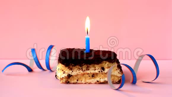 在粉红色背景和纸屑上点燃蓝色蜡烛的提拉米苏蛋糕延时录像视频的预览图