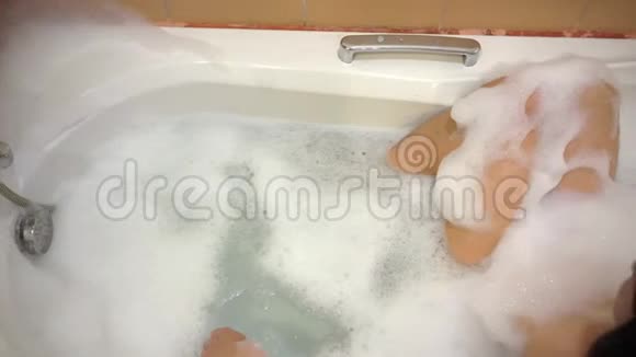 女孩躺在浴室里在白色的泡沫里放松4公里视频的预览图