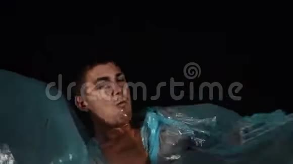 年轻人躺在蓝色玻璃纸电影里模仿海浪吐出水唱歌视频的预览图