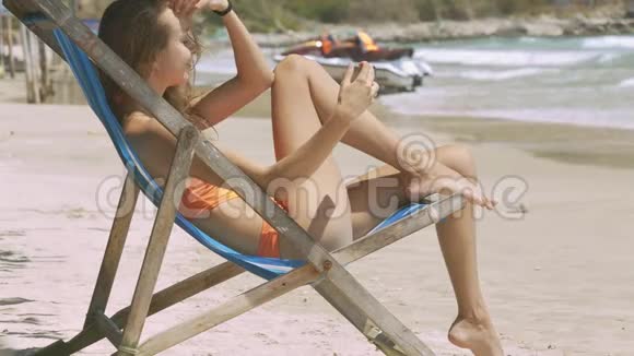 沙滩折叠椅上的苗条女孩Tans视频的预览图