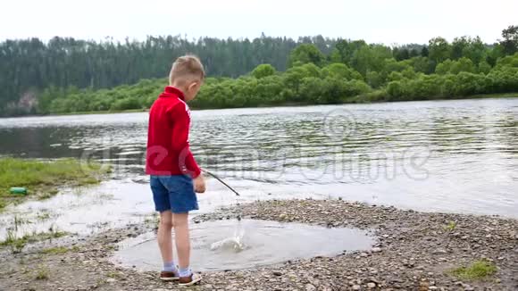 一个孩子在河岸上玩耍美丽的夏天景观户外娱乐活动视频的预览图