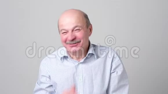 成熟的男人笑着捂住嘴用手捂住白色的背景视频的预览图