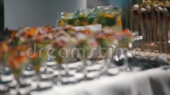 接待桌上有装满新鲜沙拉的酒杯提供室外餐桌的焦点全景视频的预览图