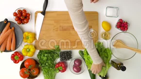 在家厨房的沙拉碗里加入生菜的女人视频的预览图