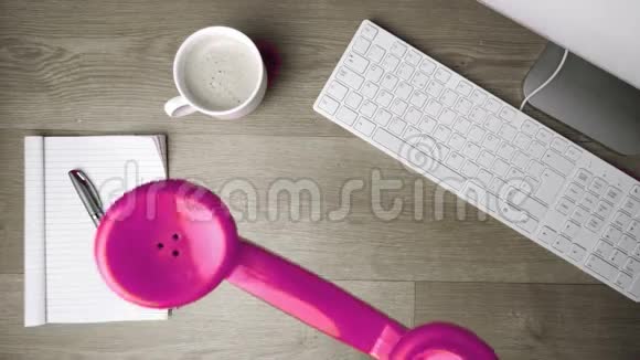 粉色电话接收器掉在办公桌上视频的预览图