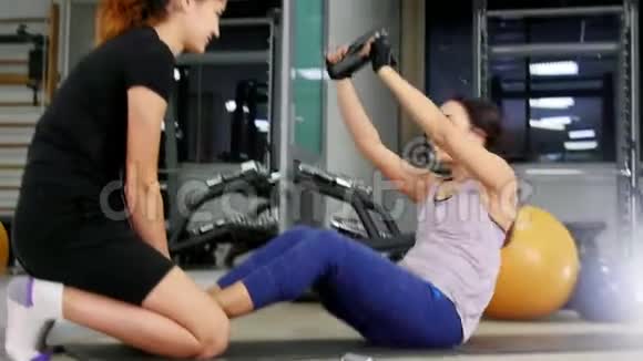 培训一位年轻女子用教练抽她的腹肌视频的预览图