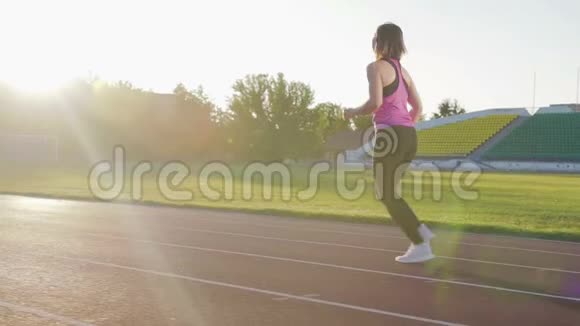 漂亮的健身女孩在体育场的跑步机上跑步青年运动员训练视频的预览图