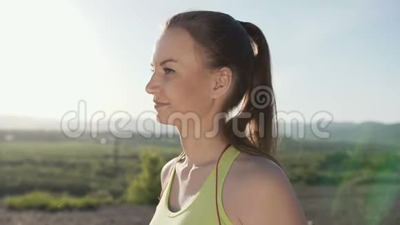 女人喝水后在森林山的背景有氧训练运动运动员女孩喝瓶装饮料视频的预览图