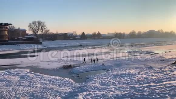 孩子们在一条结冰的河上滑行孩子们在冬天玩雪视频的预览图