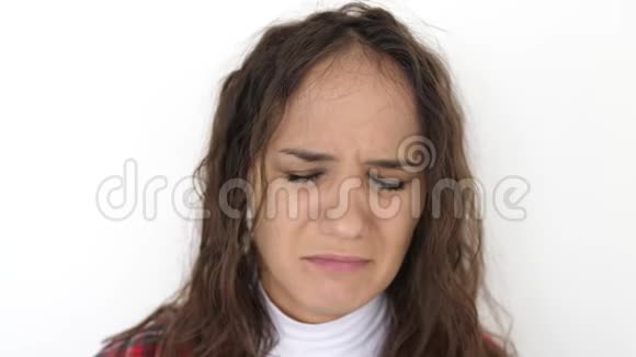 令年轻的黑发女人在白色背景上心烦意乱带着消极情绪的悲伤女人慢动作3840x2160视频的预览图