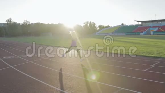 漂亮的健身女孩在体育场训练一个年轻的运动员跑跨栏视频的预览图
