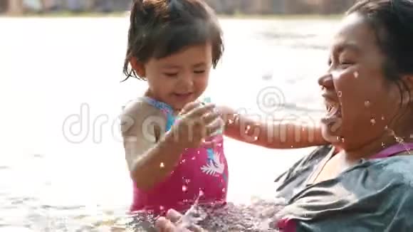 小亚洲女孩喜欢和她的阿姨在河里玩水视频的预览图