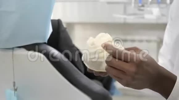 戴上医用手套带上牙科工具年轻的非裔美国男医生牙医医学卫生视频的预览图