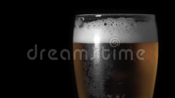 冷光啤酒在玻璃与水滴始终哑光黑色背景边框设计快来点啤酒复制空间视频的预览图