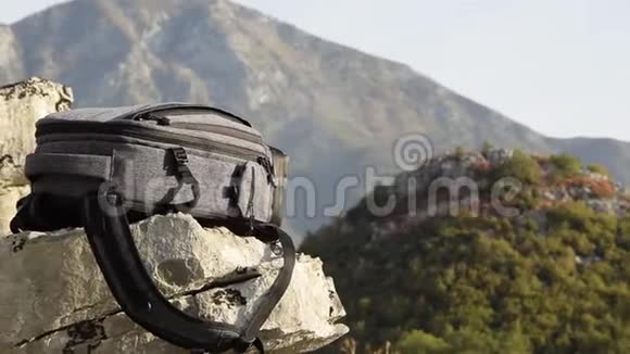 摄像机沿着山崖上的背包在美丽的山峰上移动视频的预览图