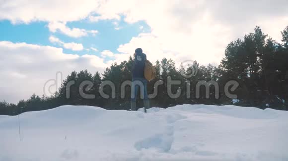 概念自由人冬手到旁边站在雪地旁边的森林慢动作视频徒步旅行者视频的预览图