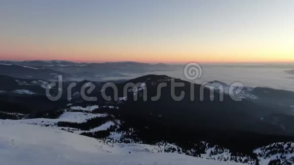 美丽的群山覆盖着雪和惊人的日落背景上有五颜六色的天空4K视频的预览图