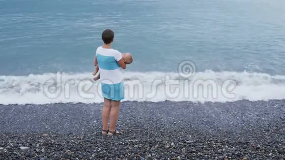 妈妈手里的熟睡的孩子沙滩上视频的预览图