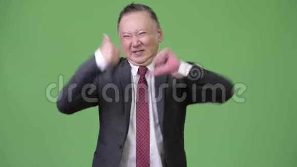 成熟迷茫的日本商人在竖起大拇指或竖起大拇指之间做出选择视频的预览图