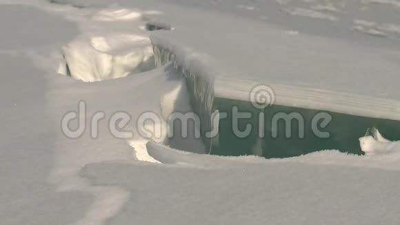 冰雪覆盖的苔原上结冰的河流视频的预览图
