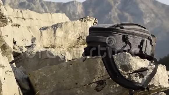 摄像机沿着山崖上的背包在美丽的山峰上移动视频的预览图