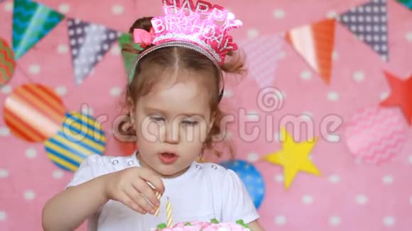 生日装饰品和装饰可爱的小女孩用蜡烛装饰一个节日蛋糕有趣快乐的孩子视频的预览图