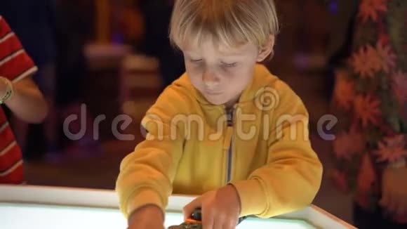 一个小男孩参观儿童科学博物馆的慢镜头他玩的是模块化机器人视频的预览图
