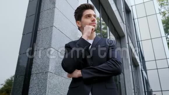 城市中成功的沉思商人的肖像在办公楼背景上穿商务西装的人帅哥视频的预览图