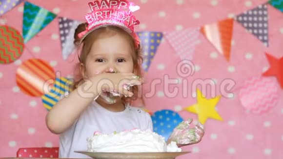 生日快乐一个可爱的小女孩吃了一个美味的蛋糕微笑着露出肮脏的脸和手一个孩子在吃视频的预览图
