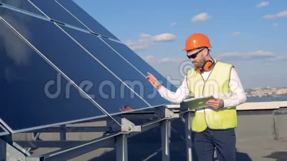 男工人正沿着太阳能电池板行走视频的预览图