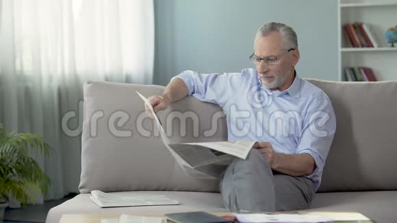 坐在沙发上看报纸看新闻休息时间视频的预览图