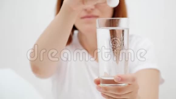 一个女孩拿着一杯水和药白色背景视频的预览图