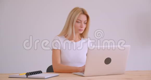 办公室内使用笔记本电脑的白种人金发女商人的特写照片视频的预览图