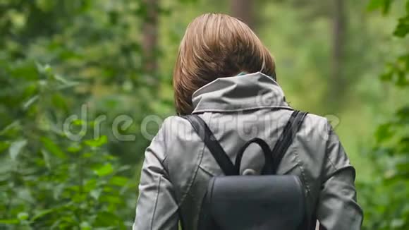一位留着短发的年轻女子漫步在秋天的公园里视频的预览图