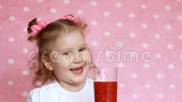 可爱的小女孩喝覆盆子冰沙微笑素食饮料儿童的特写镜头视频的预览图