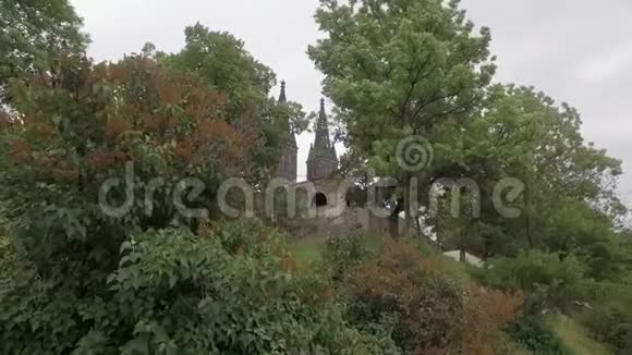 在阴天古老的中世纪大教堂的塔楼很漂亮两旁是树枝视频的预览图