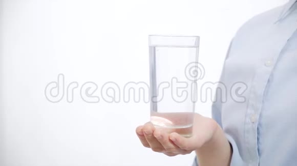 一个女孩拿着一杯水和药白色背景视频的预览图